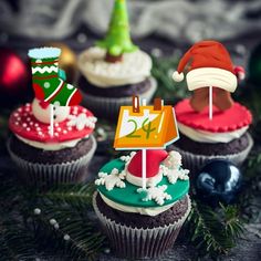 cupcakes decorated with christmas decorations and santa hats are displayed in front of ornaments