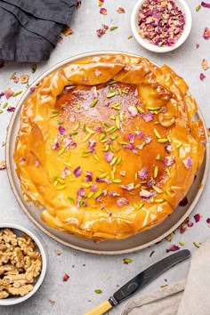 a pie sitting on top of a table next to bowls of nuts