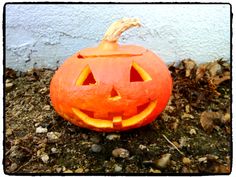 an orange carved pumpkin sitting on the ground