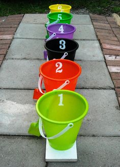 several buckets are lined up on the sidewalk with numbers painted on one side and two in the middle