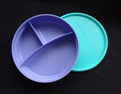 two blue and green plates sitting on top of a black tableclothed surface with one empty plate in the middle