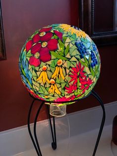 a colorful glass ball sitting on top of a metal stand