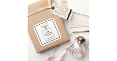 an open gift box next to a pink ribbon