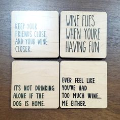 four coasters with words on them sitting on top of a wooden table next to each other