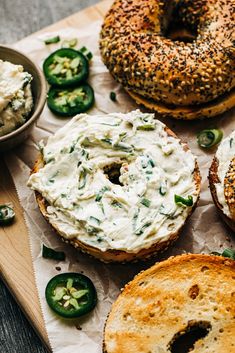 bagels with cream cheese and jalapenos on a cutting board