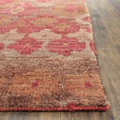 a brown and red rug on top of a wooden floor