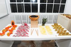 a white table topped with lots of pastries next to a potted pineapple