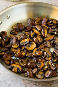 a pan filled with cooked mushrooms on top of a table