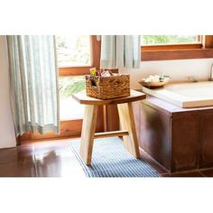 a bath tub sitting next to a window in a room with wooden floors and walls