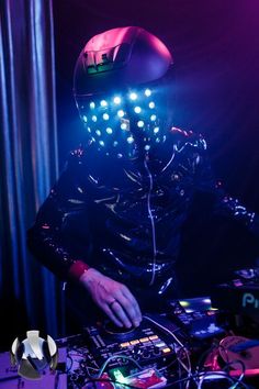 a dj is wearing a helmet and playing music