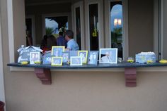 a table that has pictures on it with people looking out the window in the background