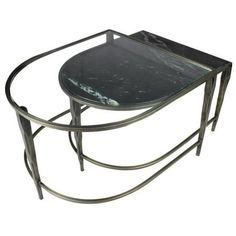 a black marble topped table with metal legs and an oval glass top on a white background