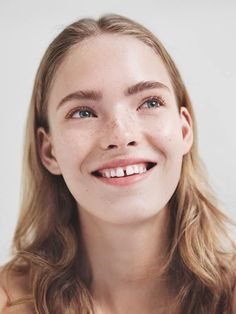 a woman with freckled hair smiling at the camera