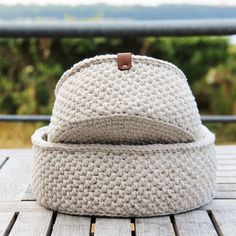 a white knitted hat sitting on top of a wooden table next to a window