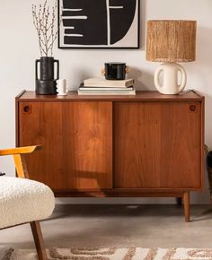 a living room with a chair, coffee pot and art on the wall above it