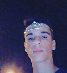 a young man wearing a tiara looking at the camera