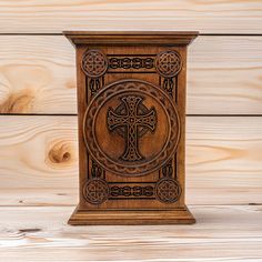 a wooden box with an ornate design on the front and sides, against a wood background