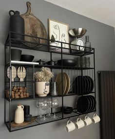 a metal shelf filled with dishes and cups