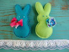 two felt bunnies are sitting on a table