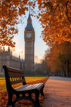 the big ben clock tower towering over the city of london in autumn, with fallen leaves on the ground