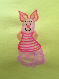 a child's drawing of a pig in pink and yellow stripes on green paper