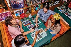 three people sitting at a table with pictures on the wall