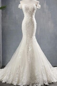 a white wedding dress with an off the shoulder neckline