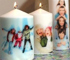 three candles with pictures on them sitting on a table