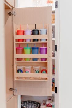 an organized pantry with cups and containers in the cupboards, including one on the bottom shelf