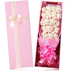 a pink box filled with lots of cookies next to a pink ribbon and present box