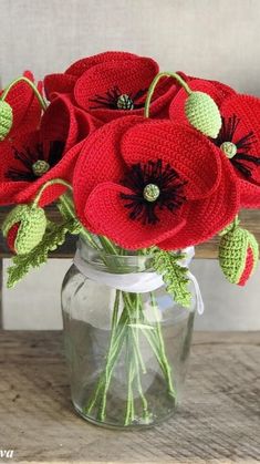 crocheted red flowers in a glass vase