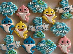 baby shark cookies decorated with royal icing are displayed on a table in front of the camera