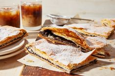 some desserts are sitting on a table next to drinks