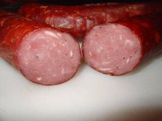 three sausages on a cutting board ready to be cooked