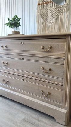 an old dresser is painted white with silver hardware