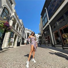 a woman in a dress is walking down the street