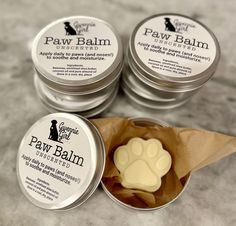 four small tins of paw balm on a table