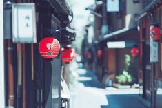 a narrow street with red lanterns hanging from the buildings