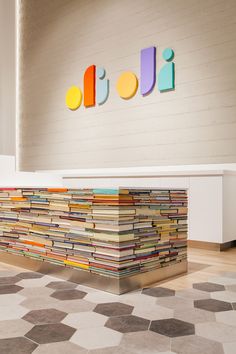 a large stack of books sitting on top of a floor next to a white wall