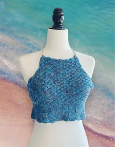 Hey there, summer blue lover! 🌊 Get ready to fall in love with this super cute and cozy crocheted crop halter top, perfect for all your summer adventures. Whether you're dancing the night away at a festival or soaking up the sun at the beach, this top is your new best friend! 🐚 Adorable Seashell Texture: This top is all about those beachy vibes, with a unique seashell crocheted pattern that's as dreamy as a seaside sunset. You'll notice a row of sea shells in different color - those are scrap Sleeveless Knit Halter Top For Beach, Blue Sleeveless Knit Crochet Top, Beach Knit Fitted Halter Top, Beach Fitted Knit Halter Top, Casual Crochet Sleeveless Halter Top, Fitted Knit Halter Top For The Beach, Crochet Sleeveless Crop Top For Beach Season, Knit Halter Neck Tank Top For The Beach, Stretch Crochet Sleeveless Halter Top