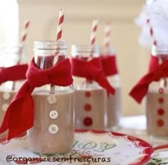 three mason jars filled with chocolate milk and decorated with red bows, sitting on a plate