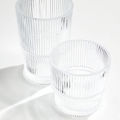 two clear glass cups sitting next to each other