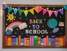 the back to school bulletin board is decorated with rainbows and books on blackboard