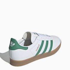 White leather trainer from adidas Originals featuring a round toe, green leather side stripes, a lace-up fastening, a branded tongue and a natural rubber sole. Fit: Buy one size larger than your usual size.Leather upper/ Rubber sole Adidas Originals Gazelle, Green Sneakers, Leather Trainers, Side Stripe, Green Leather, Natural Rubber, Sneakers White, White Green, Alexander Wang