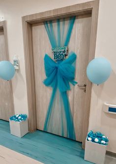 a door decorated with blue ribbon and balloons