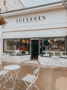 the goods store has white chairs and tables outside