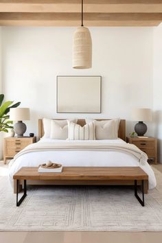 a large bed sitting under a wooden beam in a room with white walls and flooring