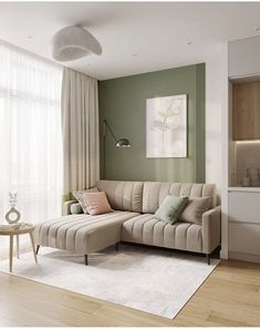 a living room with green walls and white curtains on the windowsills, a beige sectional sofa sits in front of a large window