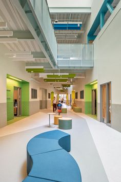 the interior of an office building with blue and green furniture on either side of it