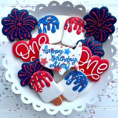 decorated cookies in the shape of hearts and fireworks on a white plate with red, white and blue icing